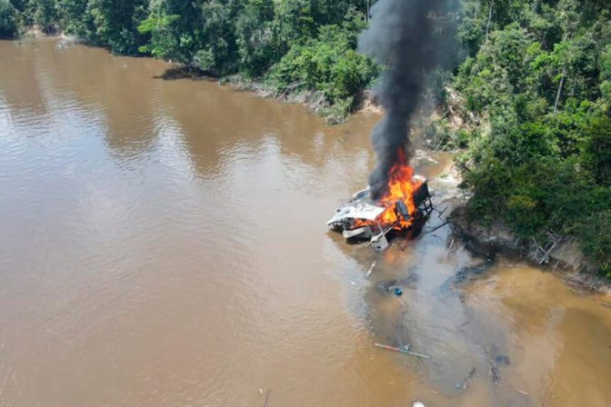 Draga minera en llamas a orillas de río en Amazonía